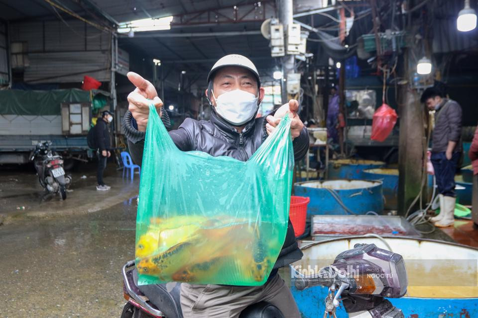 Người dân đi chợ mua cá chép về cúng ông Công ông Táo sớm.