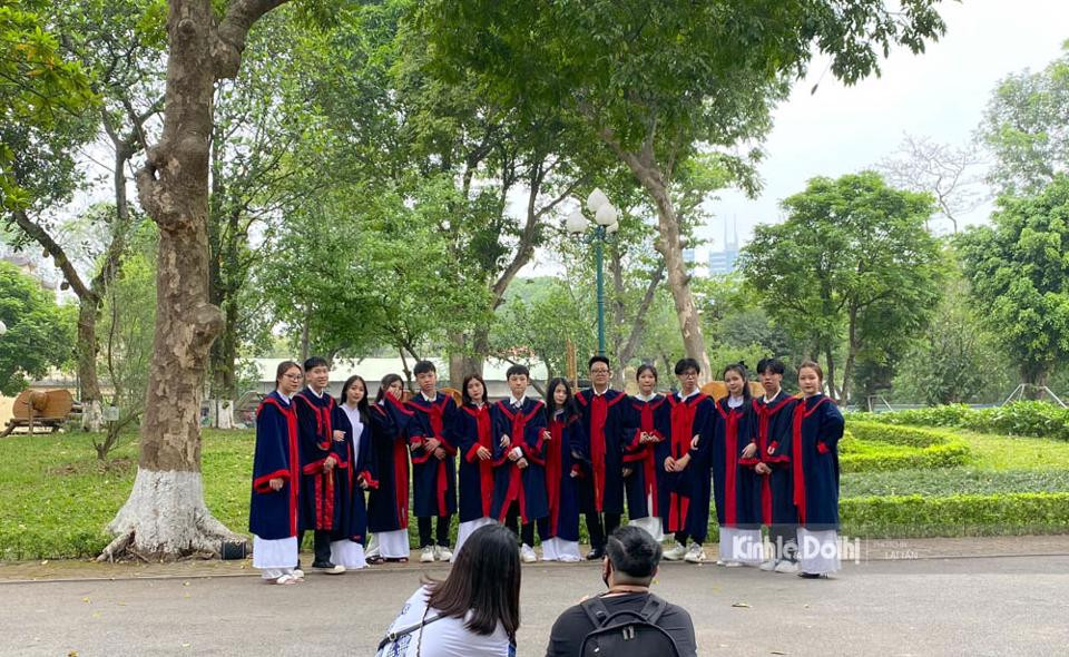 Tại Hà Nội, thời tiết cuối tuần mát mẻ, dễ chịu, học sinh trong bộ trang phục áo cử nhân dạo bước, chụp ảnh lưu niệm trong khuôn viên Hoàng thành Thăng Long.