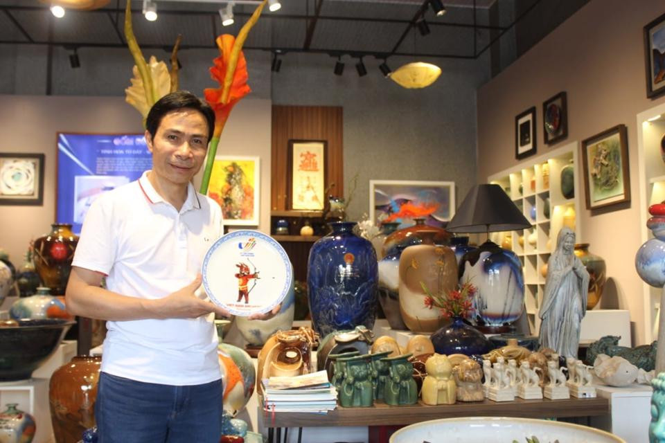 Nghệ nhân ưu tú Trần Đức Tân – Giám đốc HTX Tân Thịnh giới thiệu mẫu quà tặng in hình Sao La - Linh vật của SEA Games 31